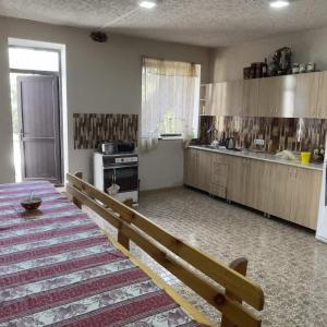 a large kitchen with a bench in a room at Mirage guesthouse in Khot