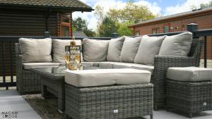 a couch and wicker chairs on a patio at Macaw Lodge in Malton