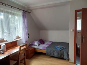1 dormitorio con cama, escritorio y ventana en Augustów Summer Camp, en Augustów