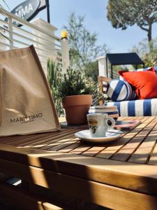 un tavolo con una tazza di caffè e una borsa sopra di MARITTIMO Milano Marittima a Milano Marittima