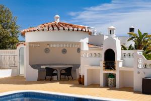 uma villa com uma piscina e uma casa em Casa Pitanga em Carvoeiro