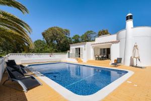 a villa with a swimming pool and a house at Casa Pitanga in Carvoeiro