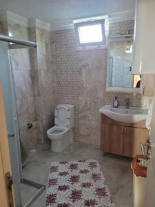 ein Badezimmer mit einem WC, einem Waschbecken und einem Spiegel in der Unterkunft Deniz Manzaralı in Arsin