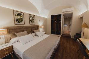 een slaapkamer met een groot bed en een raam bij Olivae Hostal Boutique in Cáceres