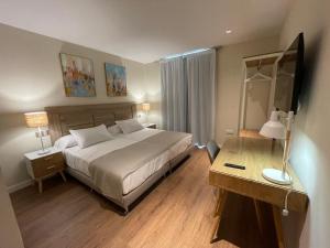 a bedroom with a bed and a desk with a mirror at Olivae Hostal Boutique in Cáceres +17 photos