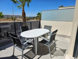 un tavolo bianco e 4 sedie su un balcone di Realrent Neo Mediterráneo a Barrio-Mar