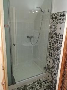 a shower with a glass door and a tile floor at Gästehaus Fuchsröhre in Welcherath