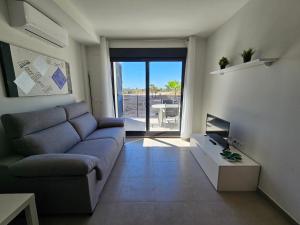 uma sala de estar com um sofá e uma televisão em Realrent Neo Mediterráneo em Barrio-Mar