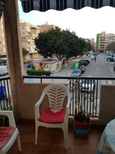 Un balcón con una silla blanca con un cojín rojo. en Apartamento Sol y Playa, en Puerto Sagunto 3 fotos más