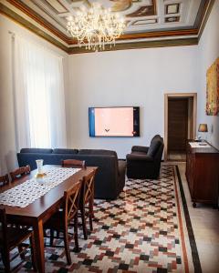 uma sala de estar com uma mesa e uma televisão em L'Affresco Affittacamere em Campolattaro