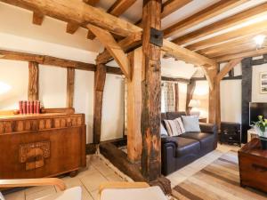 a living room with a couch and a tv at Wren Cottage in Canterbury