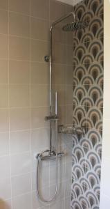 łazienka z prysznicem i ścianą wyłożoną kafelkami. w obiekcie Eleftheria Studios w mieście Balíon