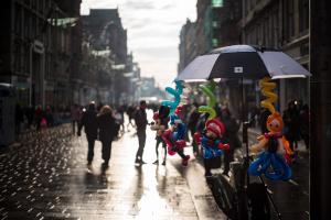 people walking down a street with umbrellas at Apex City of Glasgow Hotel in Glasgow