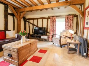 a living room with a couch and a tv at Blackbird Cottage in Canterbury