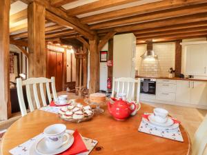 a wooden table with a tea pot and cups on it at Blackbird Cottage in Canterbury