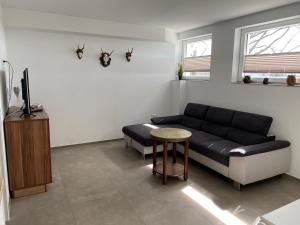 salon z czarną kanapą i stołem w obiekcie Berghof Schmitte w mieście Winterberg