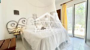 a white bed with a white canopy in a room at MiRADOR DEL FARO in Cala en Bosc