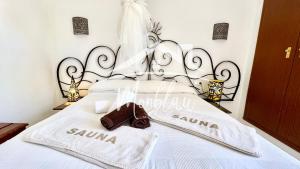 a bed with a black and white headboard and towels on it at MiRADOR DEL FARO in Cala en Bosc
