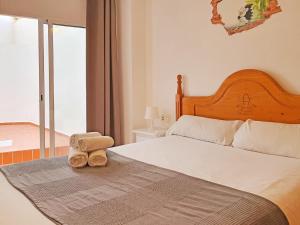 a bed with two towels sitting on top of it at Apartamentos Turquesa La Carihuela in Torremolinos