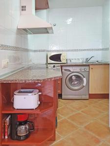 een keuken met een wastafel en een wasmachine bij Apartamentos Turquesa La Carihuela in Torremolinos