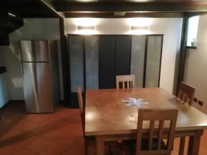 a wooden table with chairs and a refrigerator in a room at Monastero Maggiore 2 in Cividale del Friuli