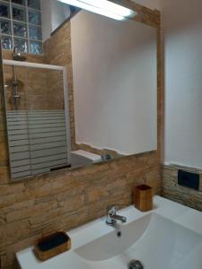 een badkamer met een wastafel en een grote spiegel bij perla spiaggia in Leni