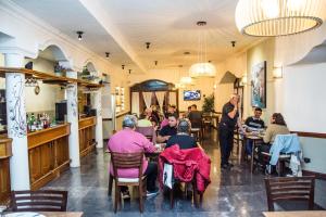 un grupo de personas sentadas en mesas en un restaurante en Hotel Santa Catalina en Río Cuarto