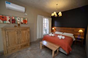 La Morada Apart Boutique & Spa في فيلا جيزيل: غرفة نوم بسرير كبير مع بطانية حمراء