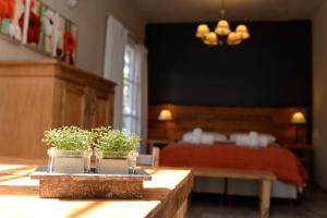 um quarto com uma cama e dois vasos de plantas sobre uma mesa em La Morada Apart Boutique & Spa em Villa Gesell