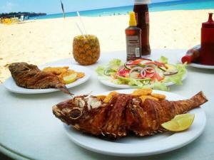 a table with two plates of food on the beach at Casa Linda 10 mins from Beach-Lagoon in Payita