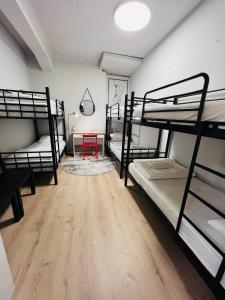a room with four bunk beds and a wooden floor at Ofek's place - Midtown TLV in Tel Aviv