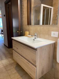 ein Badezimmer mit einem weißen Waschbecken und einem Spiegel in der Unterkunft Casa Monte Zebio in Asiago