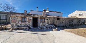 un piccolo edificio in pietra con una porta di fronte di casa rural La Cuadra a Villar de Corneja