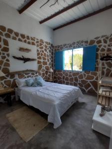 a bedroom with a bed in a stone wall at Villa Mediterránea in Tubará