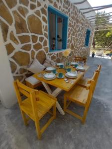 a wooden table and chairs in front of a stone wall at Villa Mediterránea in Tubará