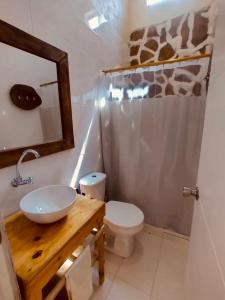 a bathroom with a sink and a toilet and a mirror at Villa Mediterránea in Tubará