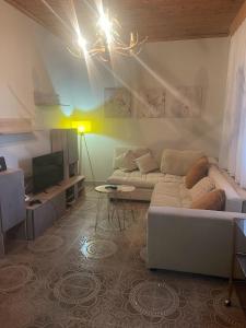uma sala de estar com um sofá e uma televisão em Valsamo Luxury Cottage em Chaïdeftón