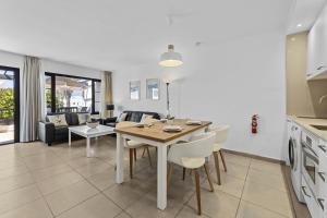 kuchnia i salon ze stołem i krzesłami w obiekcie Casahost Bastian Boutique II Seaview w Costa Teguise