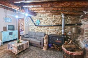 - un salon avec un canapé et un poêle à bois dans l'établissement casa rural La Cuadra, à Villar de Corneja