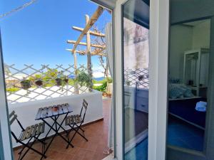 uma vista a partir da varanda de uma casa com uma mesa e cadeiras em Il Cantuccio Rooms em Capri