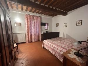 a bedroom with a bed and a table and a window at Camere Gozzante in Pienza +18 photos