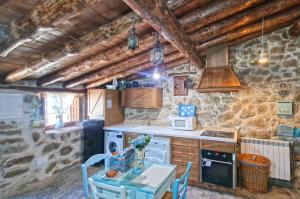 una cocina con una mesa y una estufa horno superior en casa rural La Cuadra, en Villar de Corneja