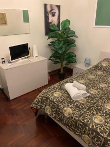 een slaapkamer met een bed en een bureau met een computer bij A Casa di Mau in Palermo