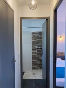 uma casa de banho com um chuveiro e um quarto com uma cama em La Geck'home em Le Barcarès