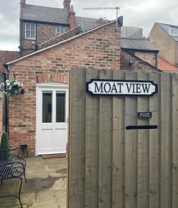 a sign on a wooden fence in front of a house at Moat View FREE PARKING, CENTRAL, EV PLUG in York
