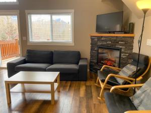 salon z kanapą i kominkiem w obiekcie Riverside Condos by Fernie Central Reservations w mieście Fernie