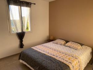 a bedroom with a bed and a window at Vacances Vallée de la Dordogne in Souillac