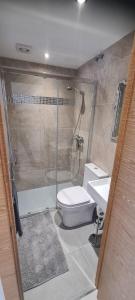 une salle de bains avec douche, toilettes et lavabo dans l'établissement Beach Haven, à Torrevieja 3 autres photos