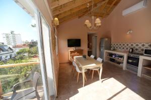 La Morada Apart Boutique & Spa في فيلا جيزيل: مطبخ وغرفة طعام مع طاولة وكراسي