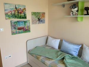 a bed in a room with paintings on the wall at Alexandra's House Nea Fokaia in Nea Fokea